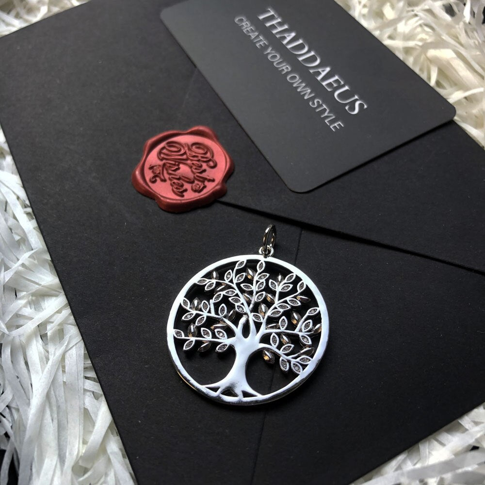 collier arbre de vie en argent posé sur une table